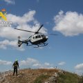 Imagen del helicóptero y uno de los agentes del Greim que rescataron a los senderistas en la Ruta Mielgo (León).