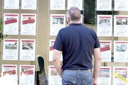 Un vecino observa las ofertas de pisos en venta y alquiler en una inmobiliaria de Valladolid. ICAL