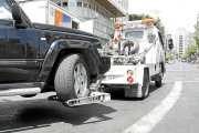 La grúa de la Policía Local llevándose un vehículo en la ciudad. Horizontal.
