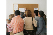 Un grupo de padres y madres comprueba la lista de admitidos en un centro. ESTHER LOBATO