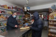 Un cliente compra pan en una tienda de alimentos y productos de primera necesidad en Amusco (Palencia). ICAL