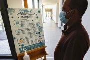 Una persona revisa el panel de las medidas contra la COVID-19. - J.M. LOSTAU