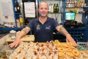 Miguel presenta desde detrás de la barra varios de los pinchos que hay en la vitrina.