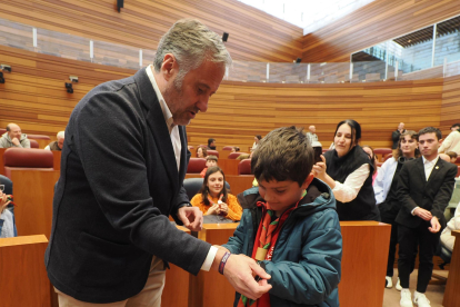 El presidente de las Cortes, Carlos Pollán, saluda a un niño