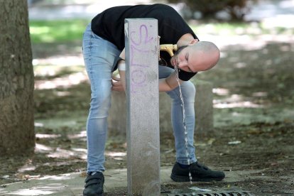 Un joven bebe agua en una fuente pública de Palencia. ICAL