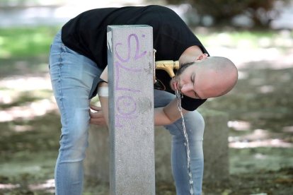 Un joven bebe agua en una fuente pública de Palencia. ICAL