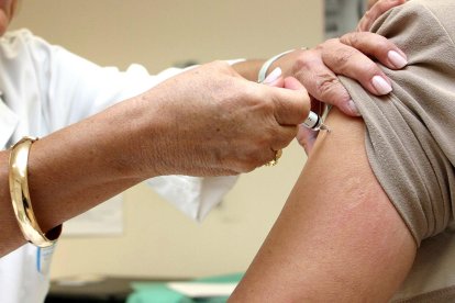 Una persona mayor se vacuna contra la gripe en su centro de salud
