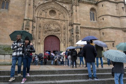 Los turistas esperan en la entrada de la catedral nueva de Salamanca.