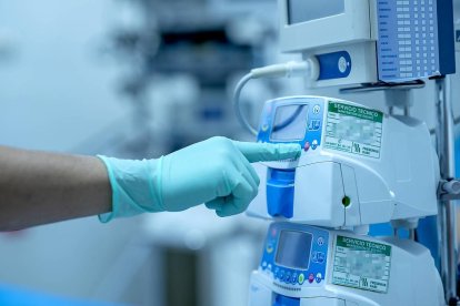 Un sanitario regula un monitor de signos vitales antes de una operación.