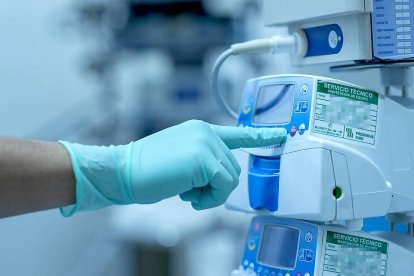 Un sanitario regula un monitor de signos vitales antes de una operación.