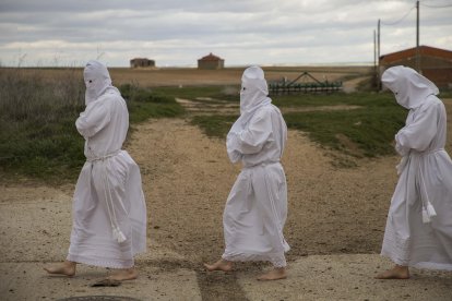 Unos penitentes en la Procesión de La Carrera en Villarrín de Campos (Zamora), al fondo unos palomares.