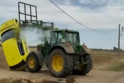 Momento en el que el tractor embiste contra el coche de la empresa de cobros.