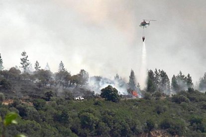 Un helicóptero trabaja en las tareas de extinción de un incendio en Congosto, en El Bierzo (León).