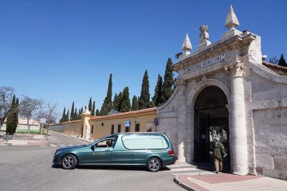 Un coche fúnebre sale del cementerio El Carmen después de un entierro .- ICAL