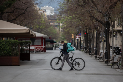 Un trabajador de Deliveroo en bicicleta por una calle vacía - EUROPA PRESS