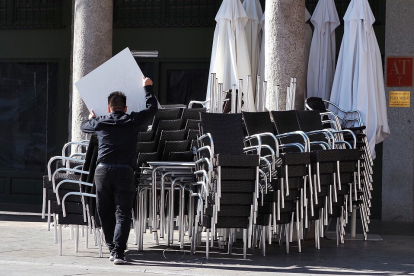 Un camarero apila las mesas de uno de los bares de la Plaza Mayor de Valladolid. MIGUEL ÁNGEL SANTOS