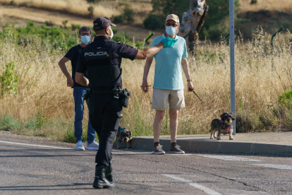 Un policía se dirige a un hombre que pasea a sus perros en el primer día de confinamiento de la localidad de Aranda de Duero (Burgos). - CESAR MANSO / AFP