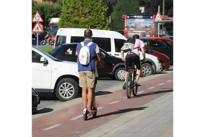 Un hombre circula en patinete y otro en bici por la avenida La Paz. - ISRAEL L. MURILLO