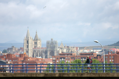 Una peregrina llega a la ciudad de León con su Catedral fondo en una imagen pasada.- ICAL