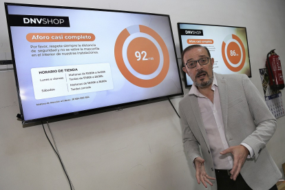 Juan Carlos Martín de ICON Multimedia de Palencia, junto a una pantallas que informan sobre el aforo en un establecimiento cualquiera