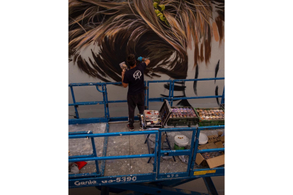 El artista 'Dadospuntocero' durante los trabajos de realización del mural en Guardo (Palencia). -ICAL