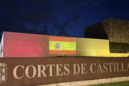 La fachada de las Cortes iluminada con la bandera de España.