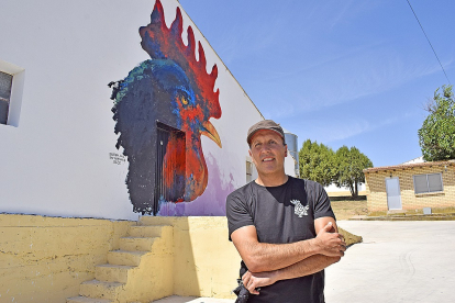 Rodrigo Barriuso, delante de uno de los murales de Villangómez, que es una alegoría a las granjas avícolas de la localidad. / ArgiComunicación