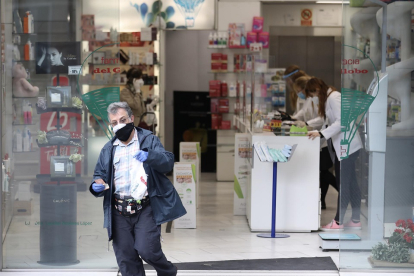 Un hombre protegido con mascarilla y guantes sale de una Farmacia. En Madrid (España) a 14 de abril de 2020. - Europa Press