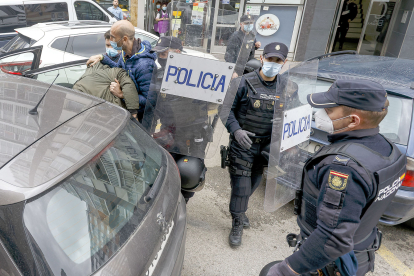Los agentes introducen en el coche a uno de los detenidos en Burgos. -SANTI OTERO