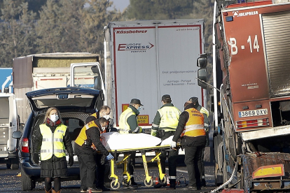 Agentes del Servicio Forense retiran el cadáver de una de las víctimas sobre la A-62, en el término de Tordesillas, ayer. J.M. LOSTAU