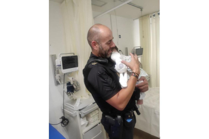 Agente de la Policía Nacional en Ávila calma a un bebé con el biberón.- TWITTER POLICIA