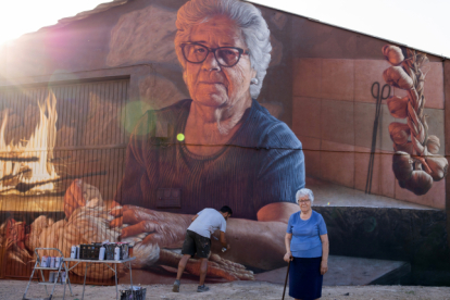 Christian Sasa trabaja en el mural con su protagonista delante. LUCAS MATÉ