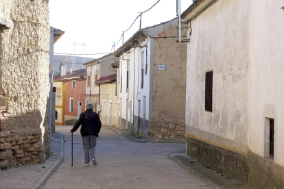 Una mujer camina por la calle de un pueblo de Valladolid