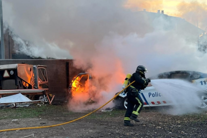 Un bombero trata de apagar el incendio de unos almacenes municipales en la localidad leonesa de Trobajo del Camino. -ICAL
