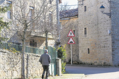Una persona mayor pasea por un pueblo de Burgos.- SANTI OTERO