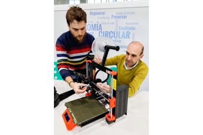 Dos personas manipulan una impresora 3D en las instalaciones del PRAE de Valladolid. J. M. LOSTAU