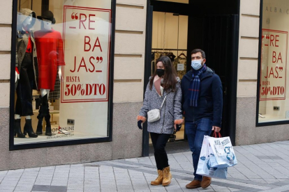 Dos personas pasan por delante de un comercio de moda en el centro de Valladolid.- J. M. LOSTAU