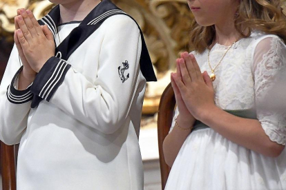 Dos niños en la eucaristía de la Primera Comunión.