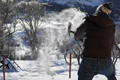 Un hombre retira la nieve con una pala en la montaña de León. / ICAL.
