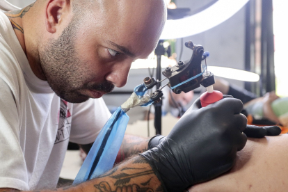 El tatuador leonés  Víctor Colado en All Street Barber & Tattoo Studio de la capital leonesa.- ICAL