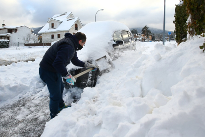 Un hombre limpia su coche de nieve ICAL