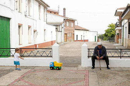 Un niño juega junto a una persona mayor en la localidad vallisoletana de Mayorga en una foto de archivo. -ICAL