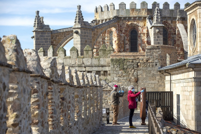 Dos turistas, este verano en la muralla de Ávila. / R. MUÑOZ