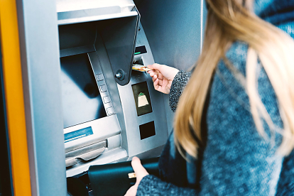 Una usuaria retira efectivo en un cajero automático utilizando su tarjeta de crédito- PQS / CCO