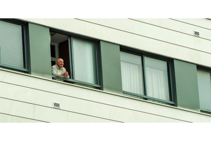 Un vecino asomado a la ventana durante el confinamiento por el COVID-19. PHOTOGENIC / M. A. SANTOS