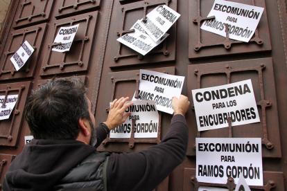 Un hombre cuelga carteles pidiendo la excomunión de Ramos Gordón en el Arzobispado de Astorga. ICAL