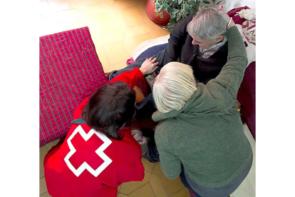 Una voluntaria de Cruz Roja visita a dos personas mayores en el marco de los programas de atención, imagen de archivo. - CRUZ ROJA