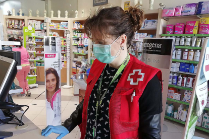 Una voluntaria adquiere medicamentos en una farmacia durante el dispositivo de apoyo habilitado durante la Covid.