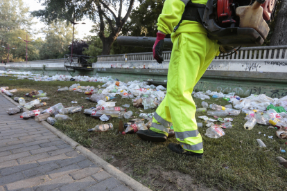 Operarios del servicio de limpieza del Ayuntamiento de León, retiran la basura acumulada en la orilla del Río Bernesga de la capital leonesa tras la noche de San Juan.- ICAL