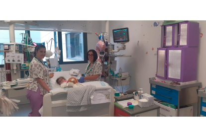 Enfermeras con una niña de dos años criada en la UCI del Hospital de Salamanca, que busca familia de acogida. -E.M.